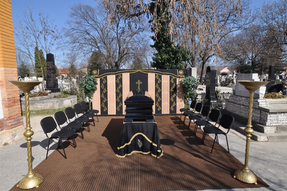 Kápolna előtt elkészített ravatal, paravánnal koporsós temetéshez