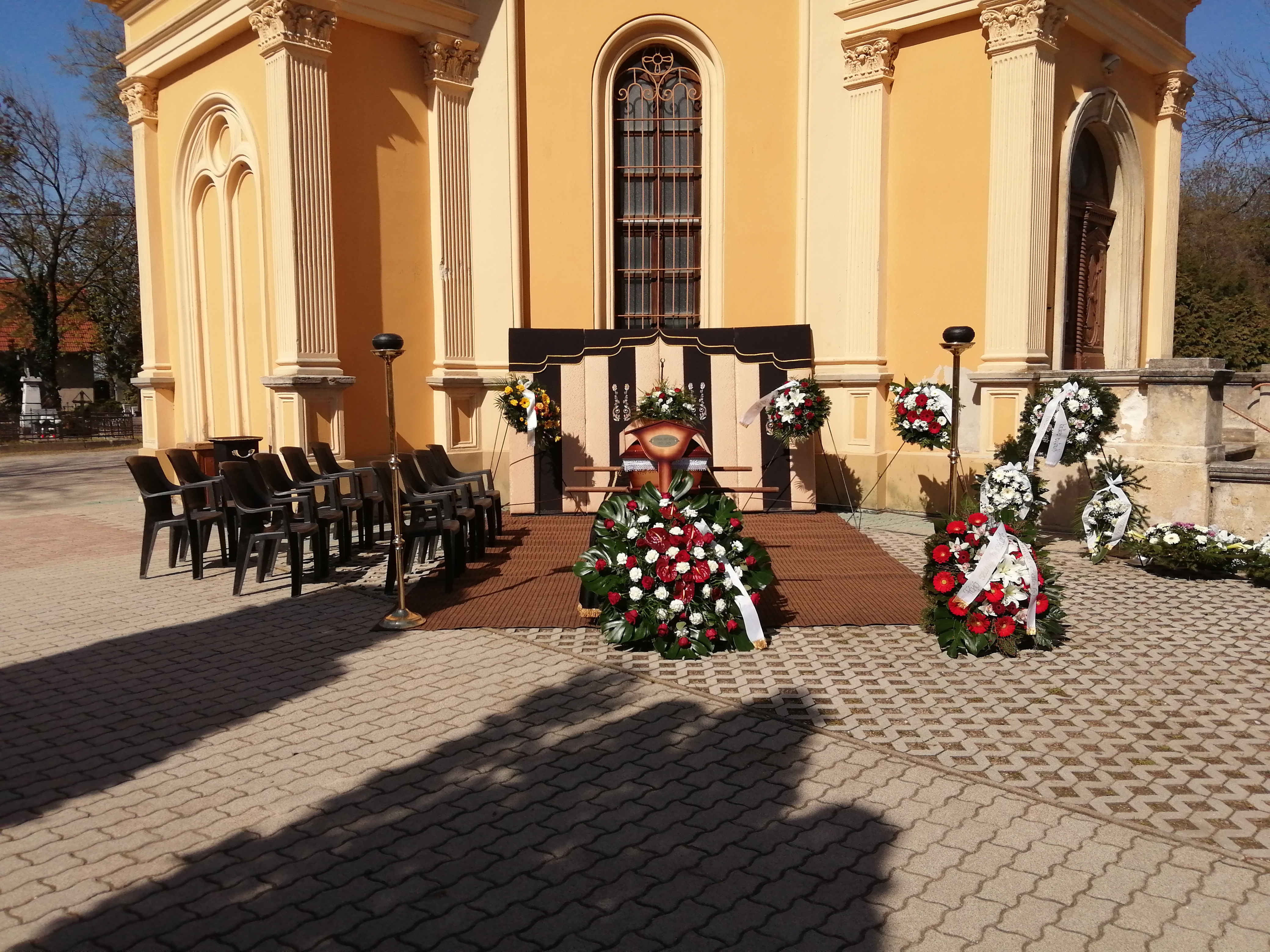 Ravatalozó tér háttérben a ravatallal melyen feldíszített koporsó áll