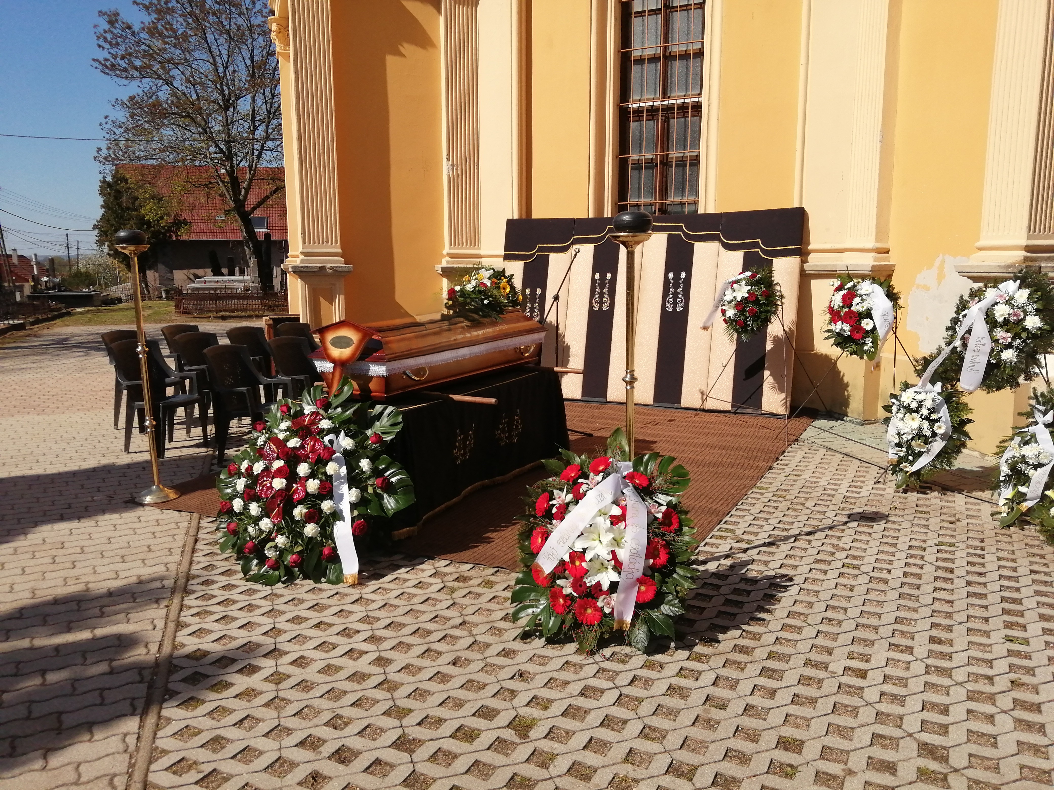 Ravatalozó tér háttérben a ravatallal melyen feldíszített koporsó áll