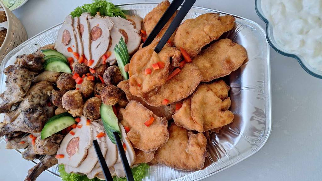 Pogácsa, gyümölcsök, üdítő bekészítés, a főfogás rántott szelet, csabai karaj, saláták.